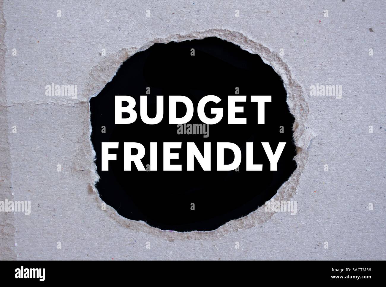 Messaggio economico scritto su carta strappata su sfondo nero. Simbolo di budget concettuale. Copia spazio. Foto Stock