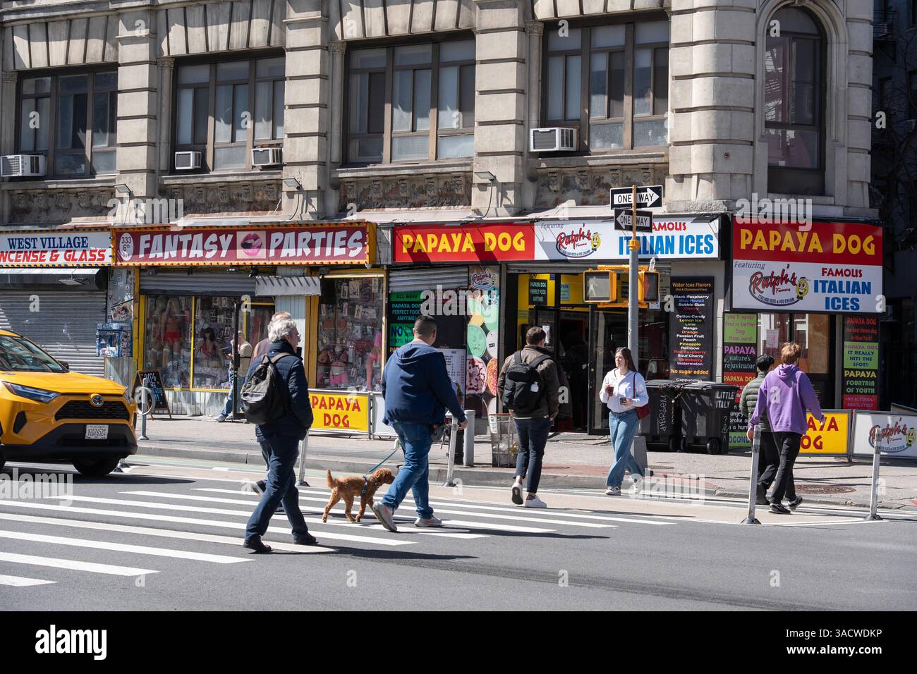Gente nel Greenwich Village che attraversa la 6th Avenue a West 4th Street a New York City. Foto Stock