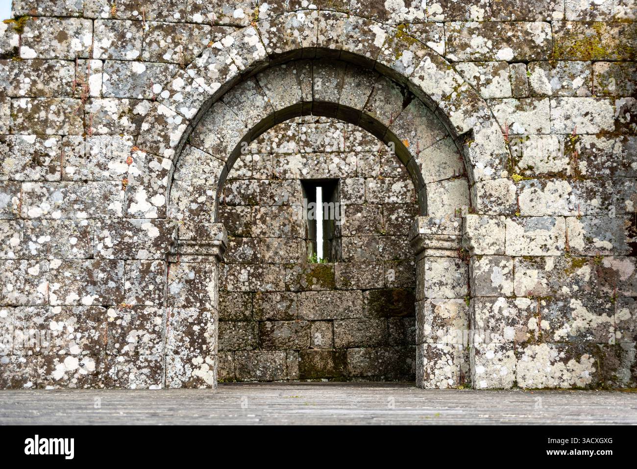 Una porta panoramica ad arco con una scappatoia nel castello medievale di Tracoso, Portogallo Foto Stock