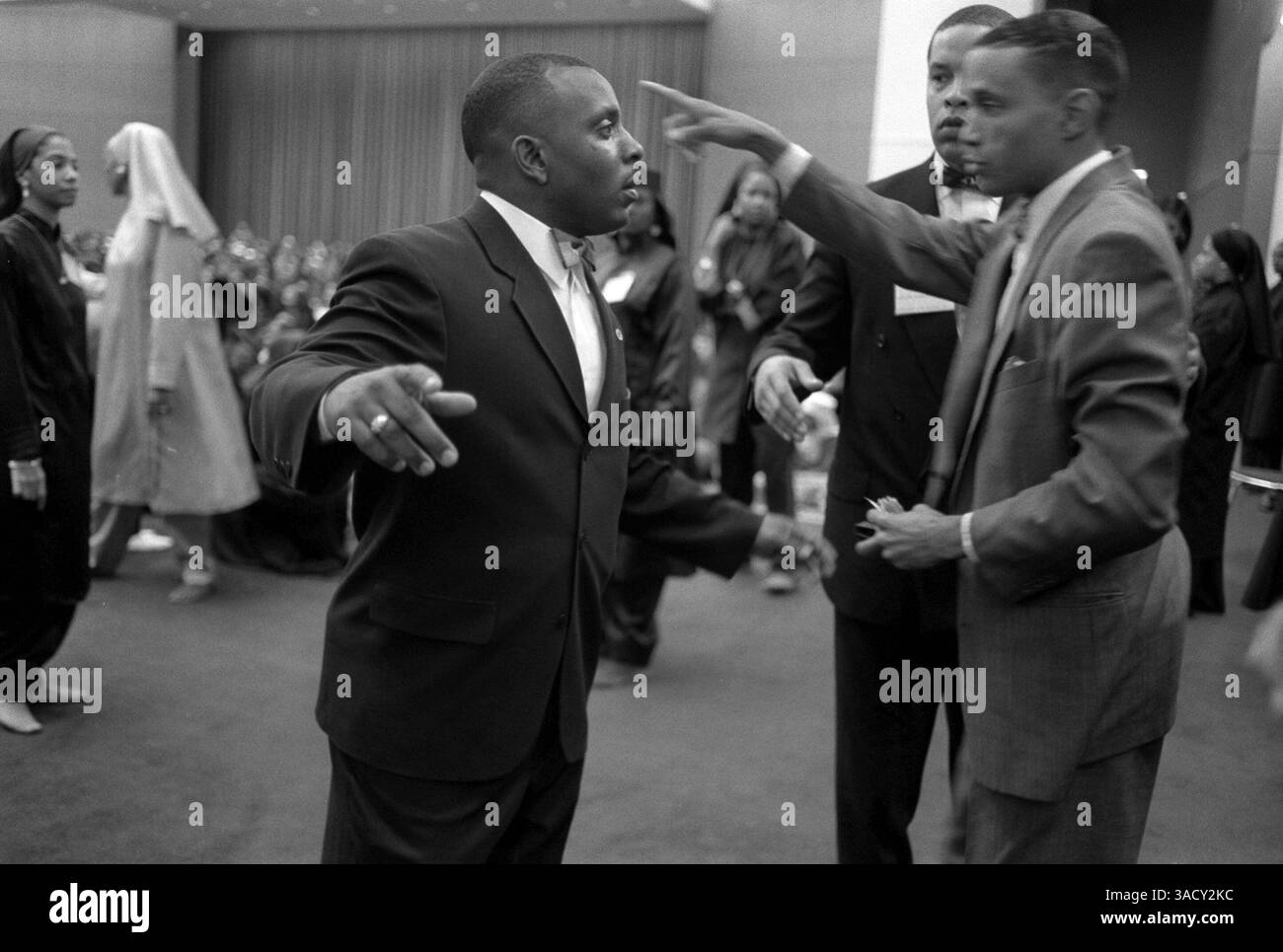 16 marzo 2004; Cleveland, Ohio, Stati Uniti; (file Photo) ad ogni incontro due membri del Fruit of Islam sono assegnati ad esaminare ogni nuovo arrivo, e lo fanno con una cura che farebbe piacere a un sergente di polizia. Le tasche devono essere ruotate all'interno verso l'esterno; revers, colletti e polsini per pantaloni sono tutti prestati attenzione. Le gambe dei pantaloni devono essere sollevate per mostrare che non c'è nulla nascosto nei calzini. Mentre le braccia del visitatore sono tenute in alto, un FOI posiziona le sue mani estese su entrambi i lati del collo e in una passata continua le segue attentamente lungo i lati del corpo fino alle caviglie. Il braccio Foto Stock