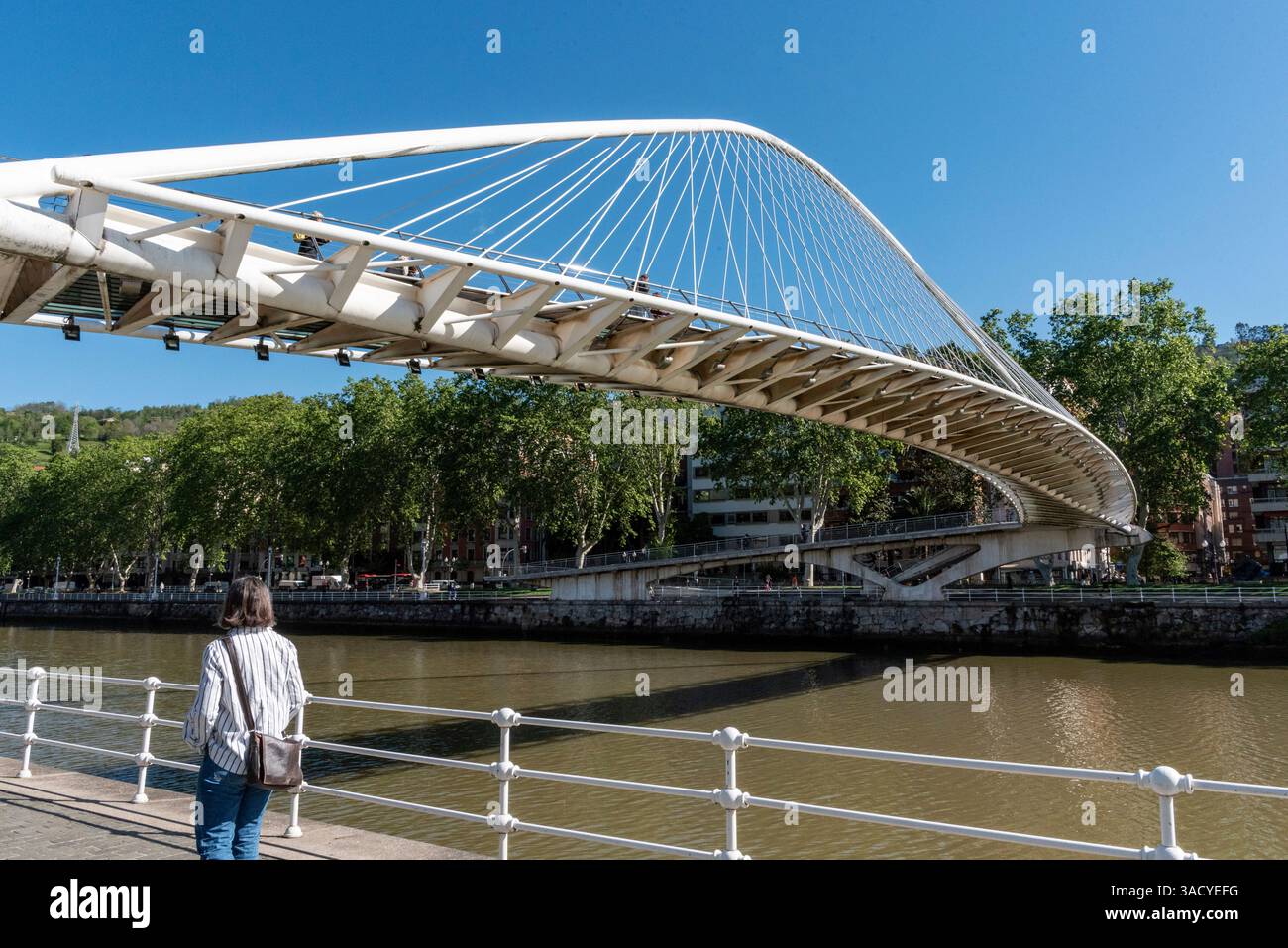 Bilbao, Spagna, l'iconico ponte Zubizuri si estende sul tranquillo fiume Nervion a Bilbao, Spagna Foto Stock