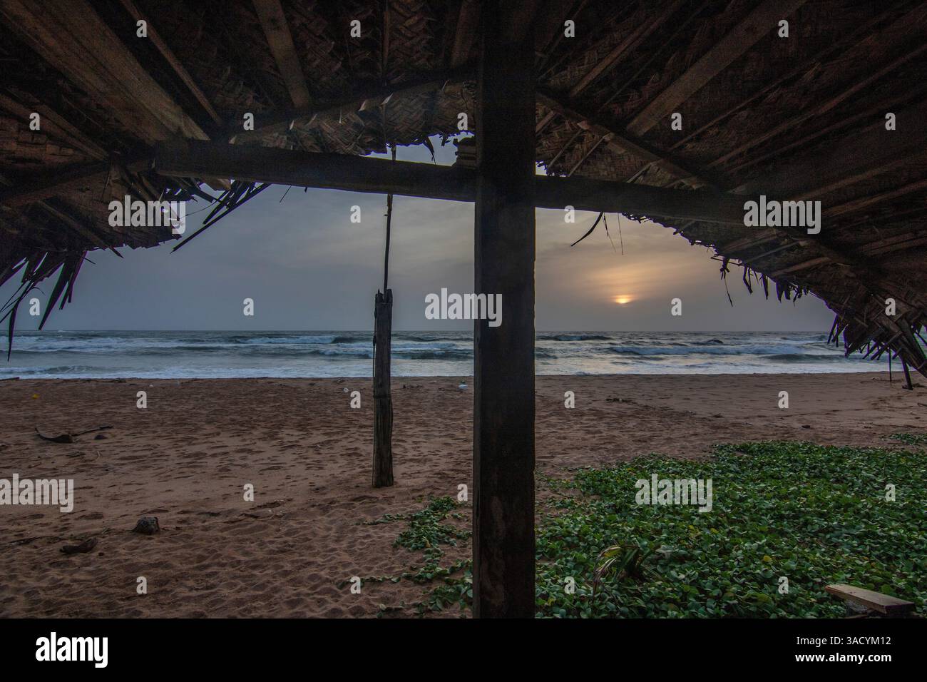 Paesaggio in riva al mare, lunga spiaggia deserta con vista sull'acqua fino all'orizzonte. Le onde di una tempesta si infrangono nella sabbia e danno un tocco speciale all'immagine al tramonto. Bentota, Sri Lanka, Asia Foto Stock
