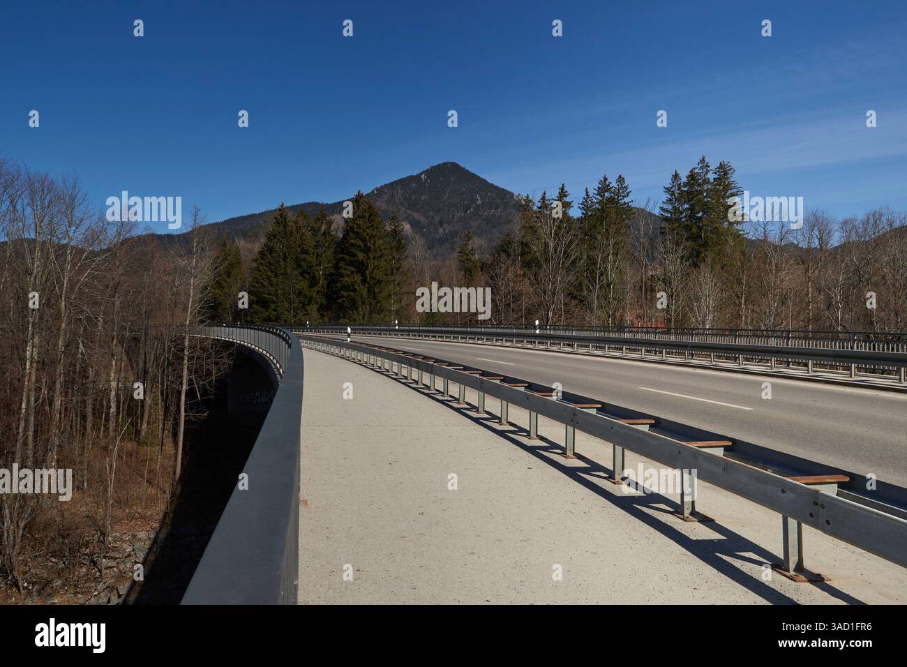 Carreggiata e pista ciclabile sul ponte bretone vicino a Lenggries in una giornata di sole a marzo. Ponte senza traffico in questo momento Foto Stock