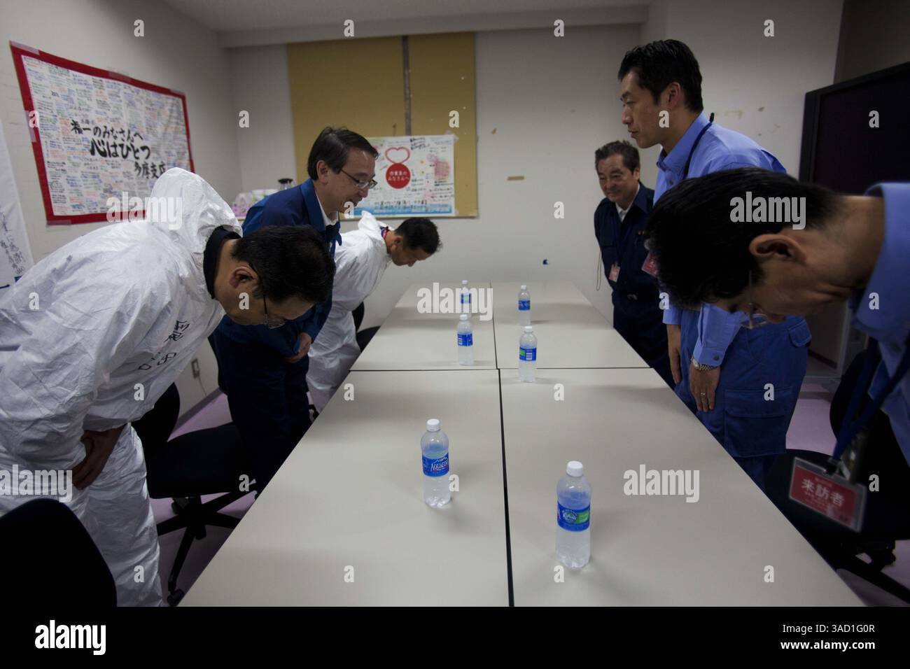 12 novembre 2011 - Tokyo, Giappone - il Ministro dell'ambiente giapponese, Goshi Hosono, al centro di destra, saluta i funzionari della Tokyo Electric Power Co., a sinistra, il centro operativo di emergenza della centrale nucleare di Fukushima dai-ichi in crisi a Okuma, Giappone sabato 12 novembre 2011. I media permisero per la prima volta di entrare nella centrale nucleare giapponese danneggiata dallo tsunami sabato vide una scena di devastazione impressionante: Veicoli contorti e rovesciati, edifici di reattori in rovina e mucchi di macerie praticamente intatti da quando l'onda colpì più di otto mesi fa. (Immagine di credito: © David Guttenfelder-P Foto Stock