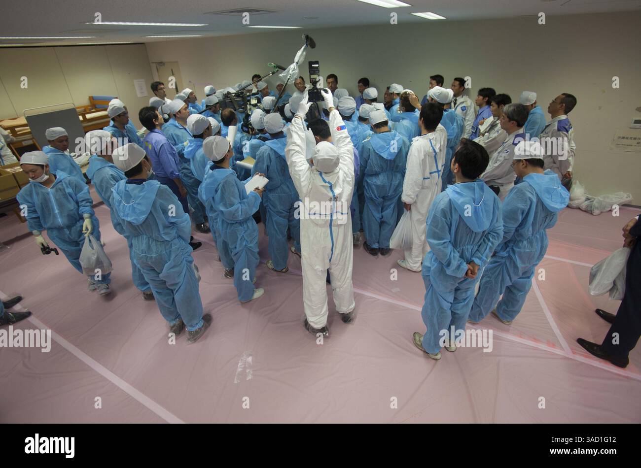 12 novembre 2011 - Tokyo, Giappone - membri dei media che indossano tute protettive, intervistano il ministro dell'ambiente giapponese, Goshi Hosono, e capo della centrale nucleare dai-ichi, Masao Yoshida, all'interno del centro operativo di emergenza presso la paralizzata centrale nucleare di Fukushima dai-ichi a Okuma, Giappone sabato 12 novembre 2011. I media permisero per la prima volta di entrare nella centrale nucleare giapponese danneggiata dallo tsunami sabato vide una scena di devastazione: Veicoli contorti e rovesciati, edifici di reattori sbriciolati e mucchi di macerie praticamente intatti da quando l'onda ha colpito più di otto metri Foto Stock