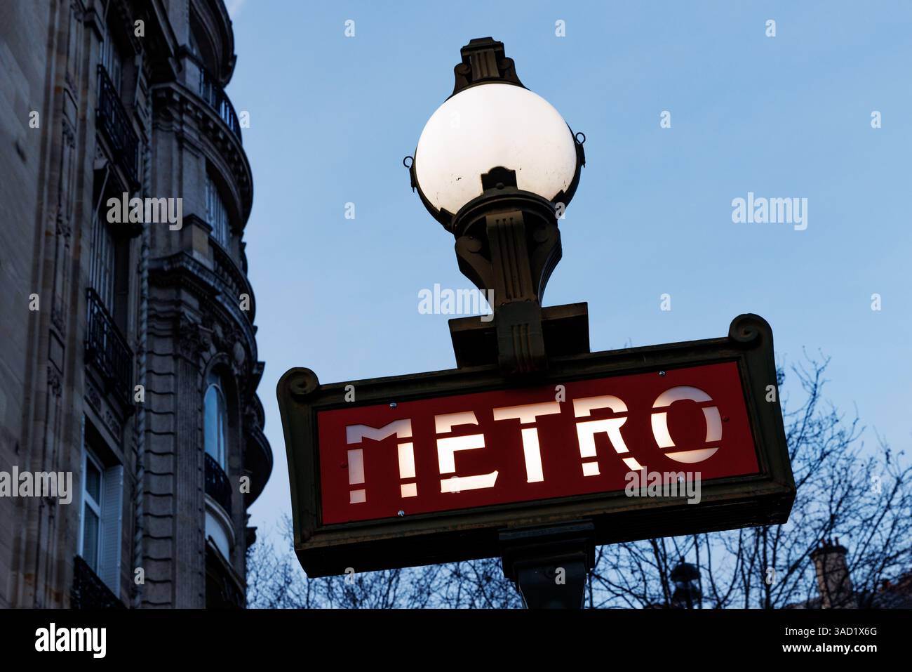 Un segno rosso e bianco con sopra la parola Metro. Il cartello si illumina di notte Foto Stock