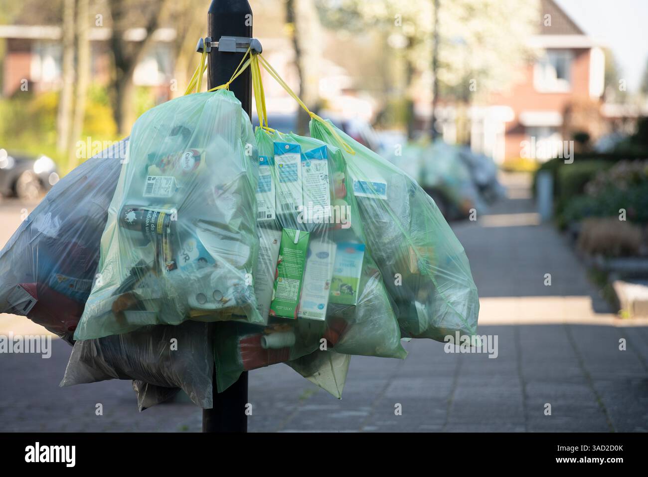Sacchetti con rifiuti riutilizzabili appesi a un lampione, pronti per la raccolta dei rifiuti, Paesi Bassi Foto Stock