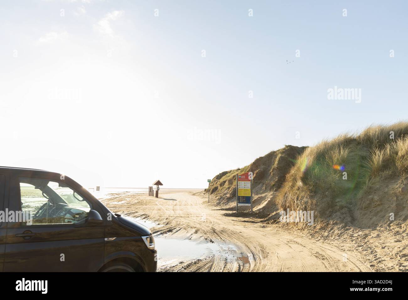 Vista laterale di un'auto sulla spiaggia che attraversa la spiaggia accessibile di Lakolk sull'isola di Römö, Danimarca, Europa Foto Stock