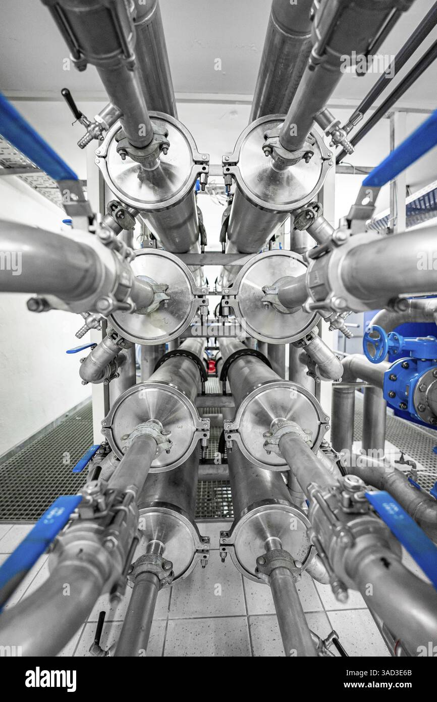 Disposizione simmetrica di tubi e valvole in metallo in ambiente industriale, ENCW Netze Calw Waterworks, Calw, Foresta Nera, Germania, Europa Foto Stock