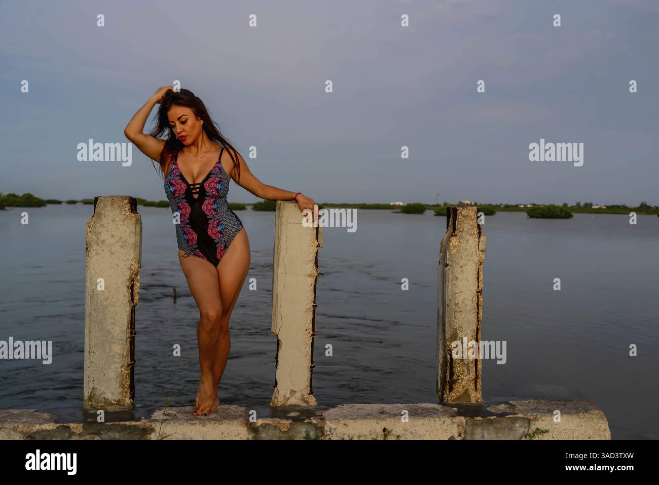 Uno splendido modello latino si posa mentre il sole sorge sul Golfo del Messico vicino a Sinanche Yucatan Messico, Telchac Puerto, Messico, America centrale Foto Stock