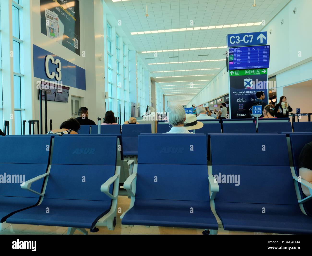 Aeroporto internazionale Manuel Crescencio Rejón a Merida, Yucatan, Messico; vista interna dell'area di attesa passeggeri al gate C3 con monitor e cartelli. Foto Stock