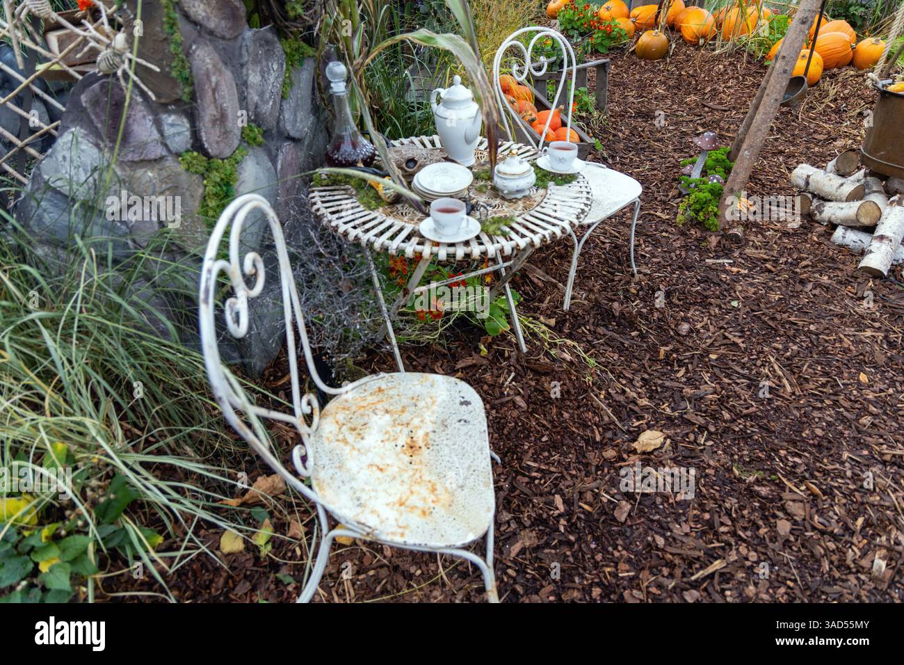 Tavolo vuoto per due nel giardino d'autunno decorato per Halloween. Foto Stock