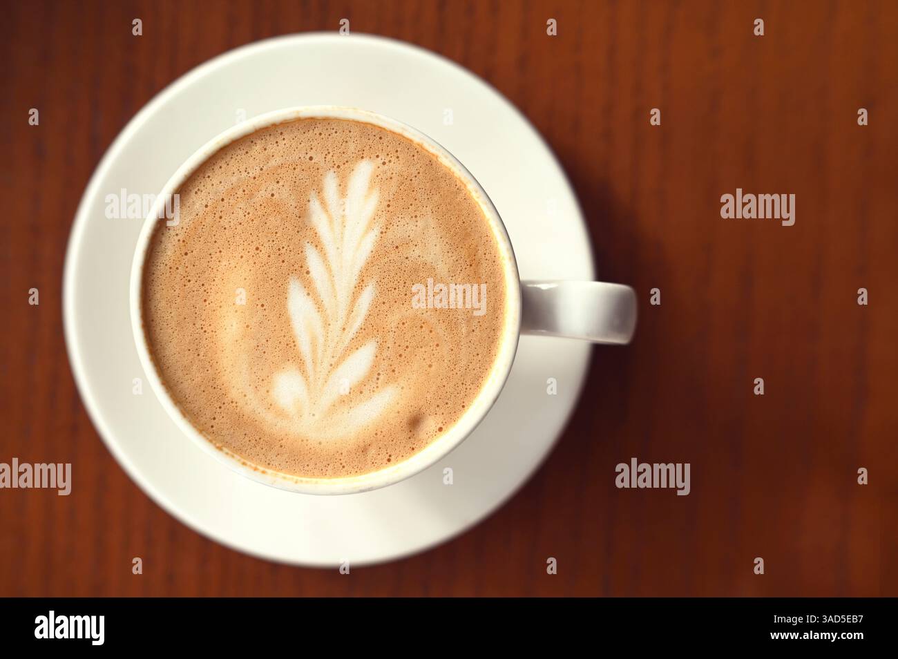 Caffè latte con schiuma di latte su un tavolo marrone al bar Foto Stock