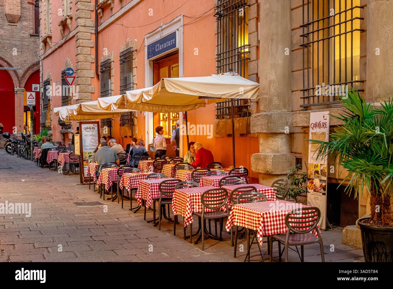 Le persone sedute fuori si godono il cibo al ristorante Clive T. Clavature in via Clavature, Bologna, Italia Foto Stock