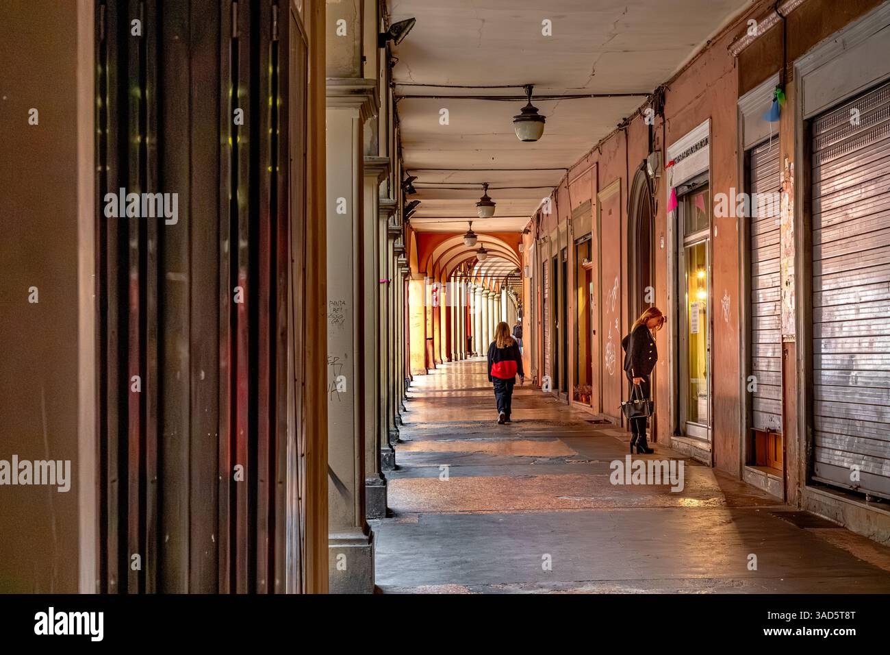 Una donna che guarda in una vetrina nel Portico di via San vitale a Bologna, Italia Foto Stock