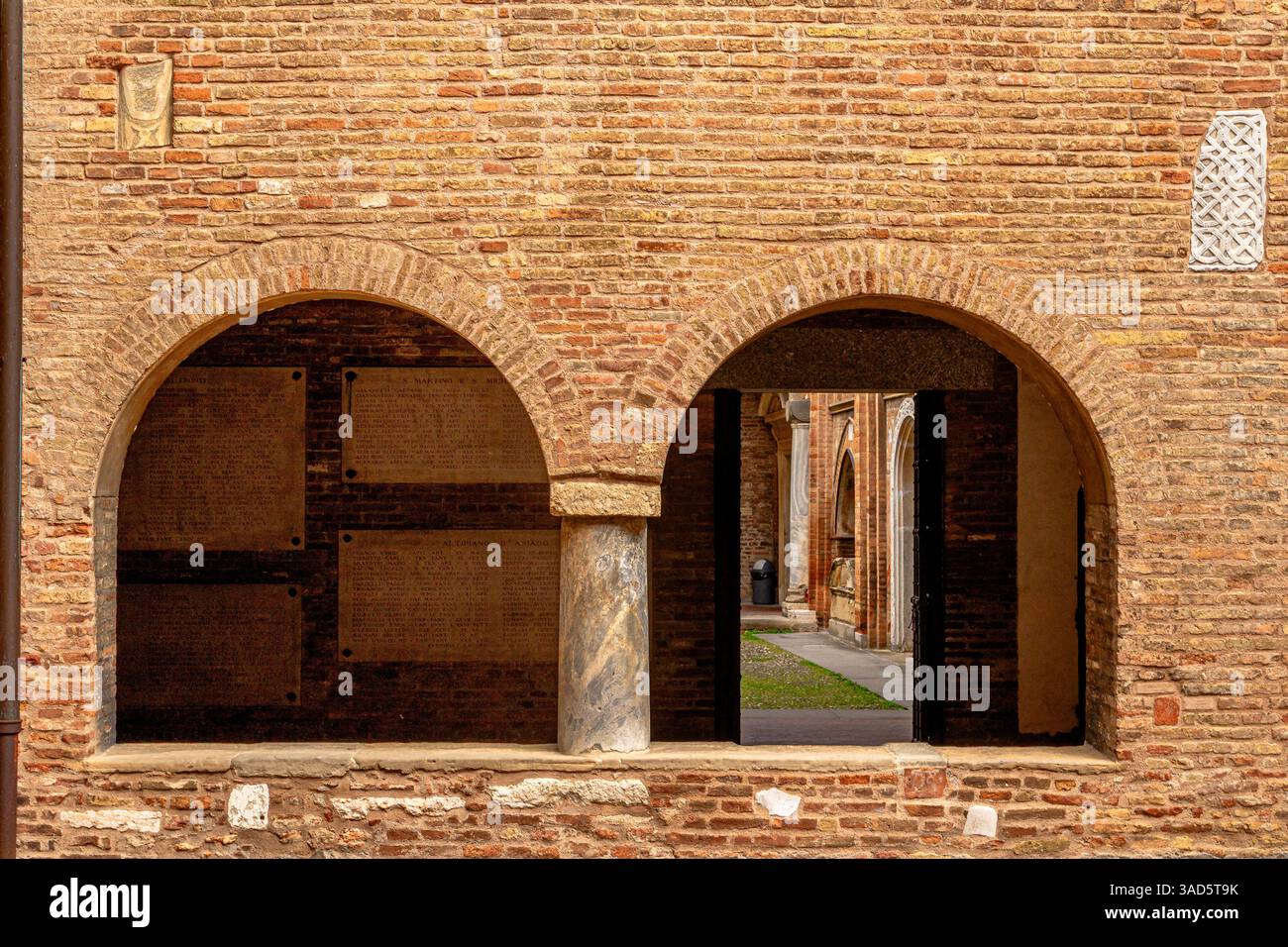 Archi gemelli in un muro di mattoni all'interno della Basilica di Santo Stefano in Piazza Santo Stefano, Bologna, Italia Foto Stock