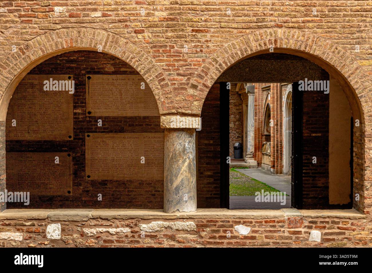 Archi gemelli in un muro di mattoni all'interno della Basilica di Santo Stefano in Piazza Santo Stefano, Bologna, Italia Foto Stock