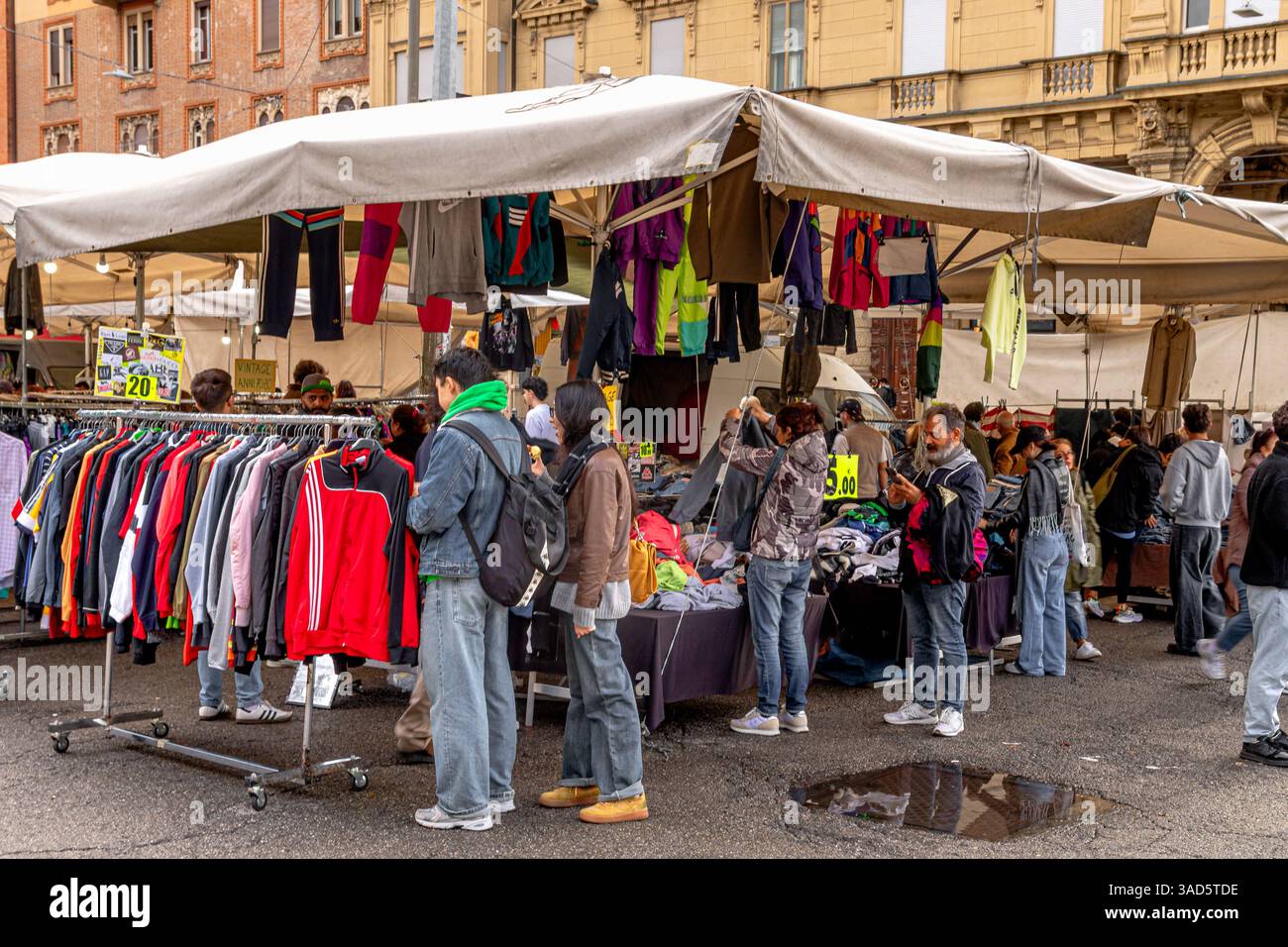 Persone che cercano vestiti in vendita al mercato la Piazzola in Piazza VIII agosto, Bologna, Italia Foto Stock