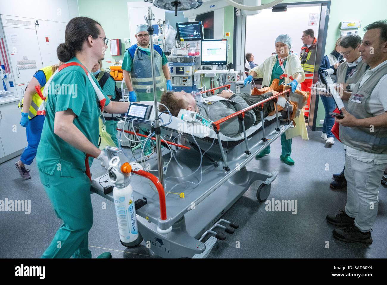 Rostock, Germania. 5 aprile 2025. Il personale infermieristico volontario e le squadre mediche trattano una vittima al Rostock University Medical Center durante un incidente simulato che coinvolge 40 persone ferite a seguito di un'esplosione in un evento sportivo e conseguente panico di massa. Nella più grande simulazione di un incidente di massa a Rostock University Medicine, l'organizzazione di cure mediche in caso di crisi è stata testata. Crediti: Stefan Sauer/dpa/Alamy Live News Foto Stock