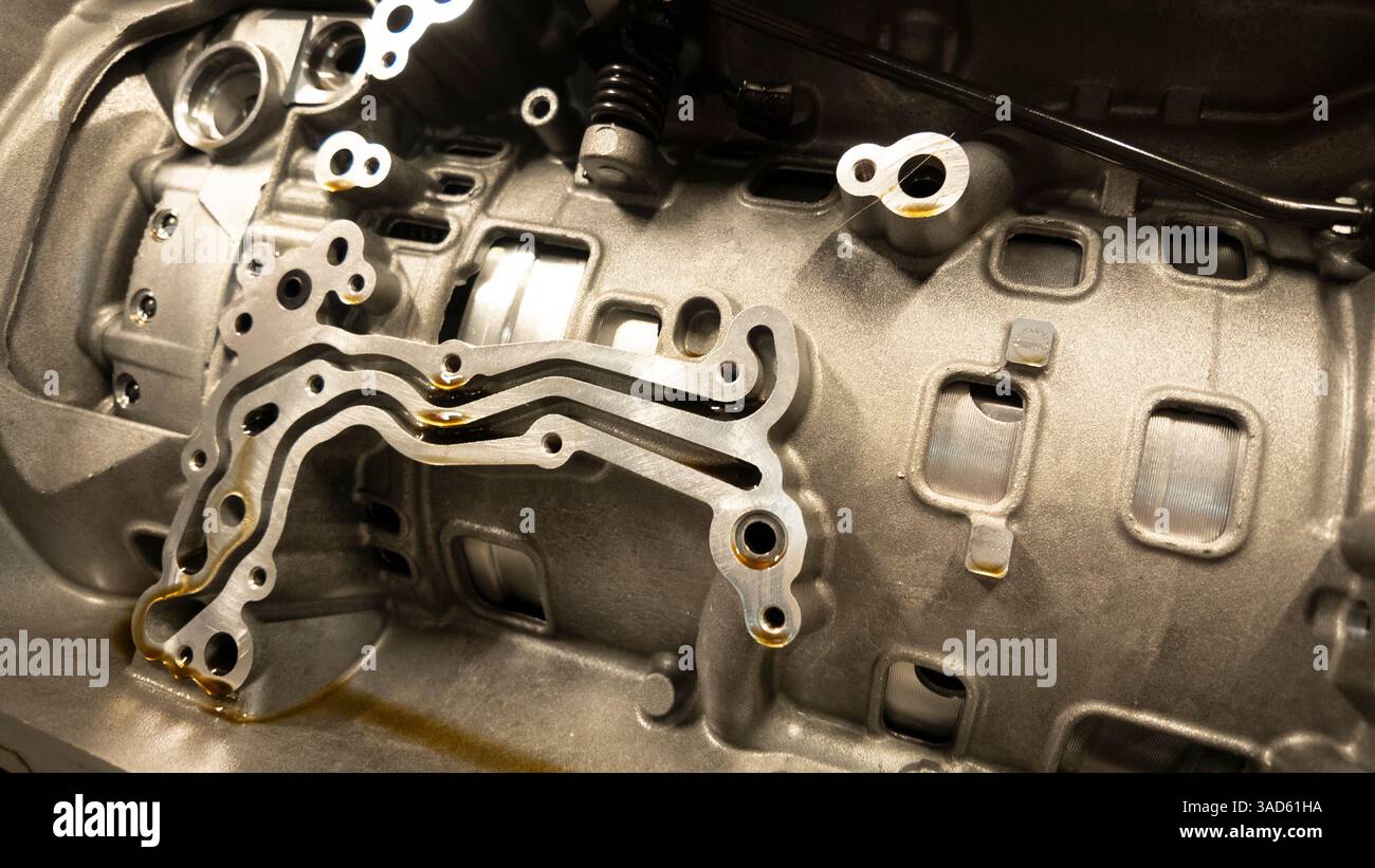 L'olio scorre attraverso i canali di un monoblocco, evidenziando la complessa progettazione e l'ingegneria di precisione della tecnologia automobilistica Foto Stock