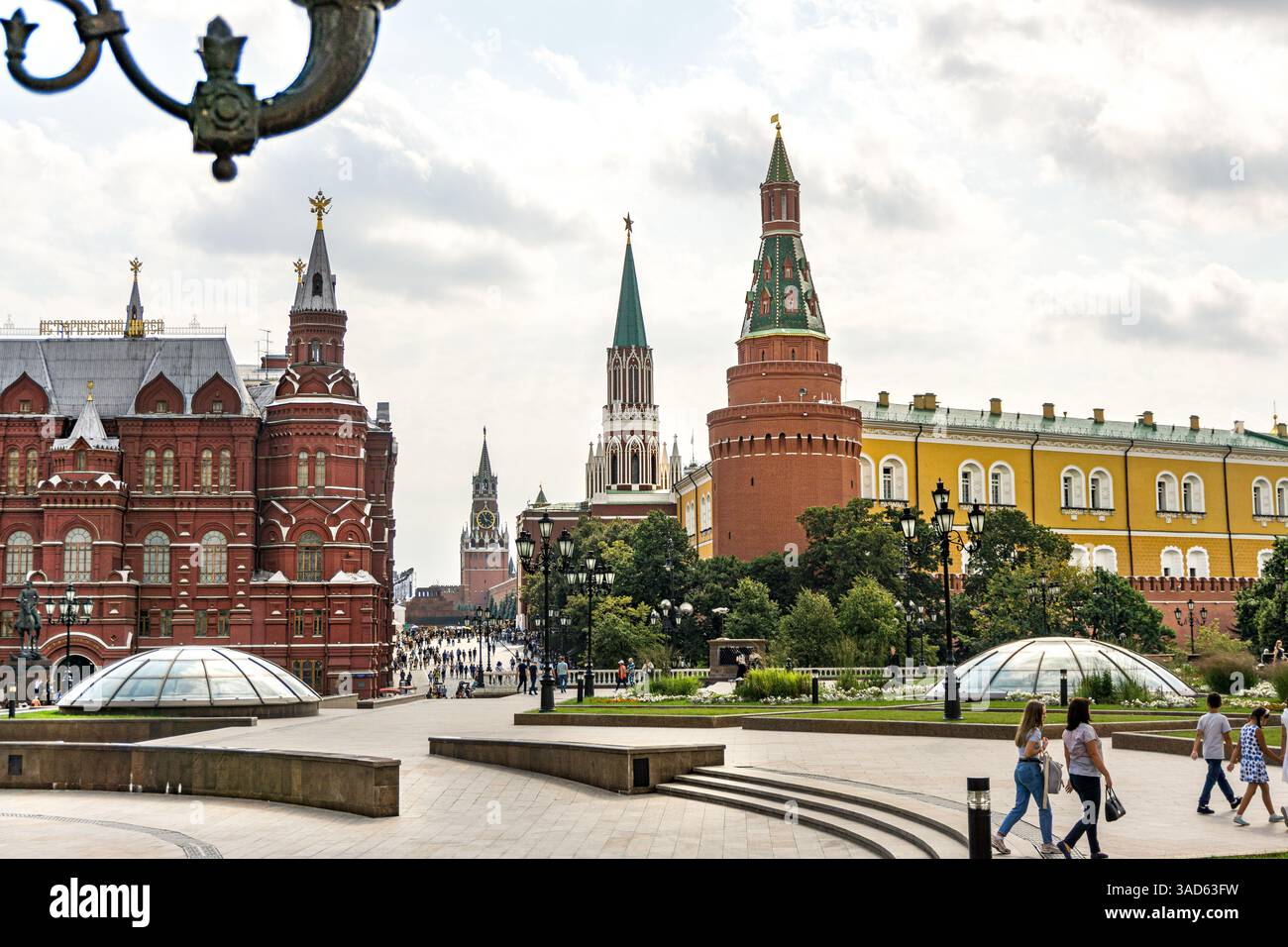 Una piazza della città giardino alexander a Mosca in Russia con un grande edificio sullo sfondo. Ci sono delle panchine e alcune persone sedute su di loro Foto Stock