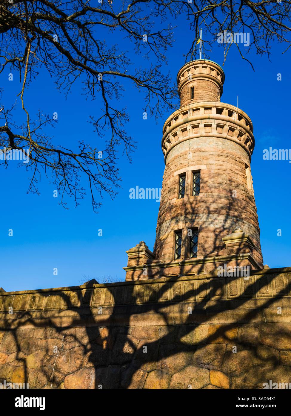 Questa impressionante torre d'acqua di Gothenburg presenta intricati lavori in pietra e una presenza dominante contro un cielo blu brillante. Le ombre della torre giocano sulla g Foto Stock