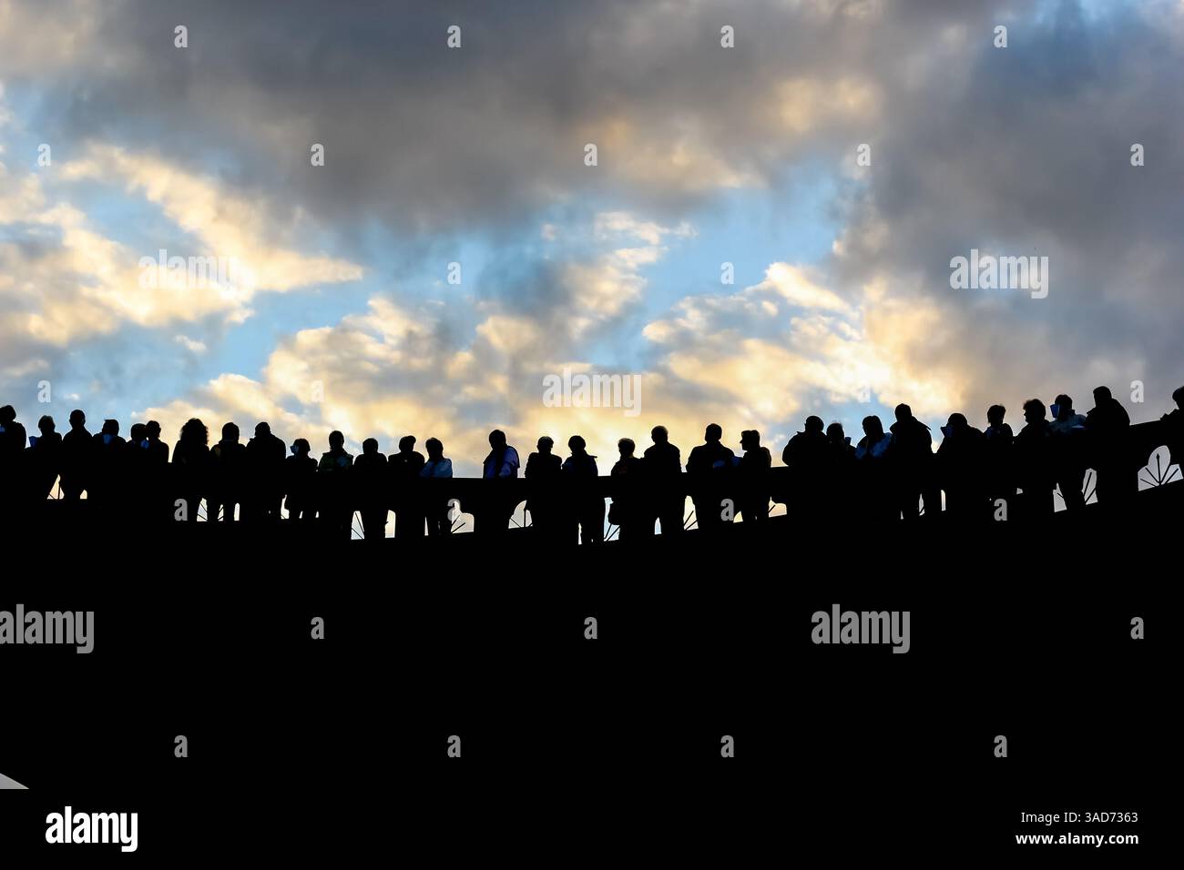 Gruppo di persone diverse sagome in piedi e guardando verso la luce. Piacere dopo aver completato il pellegrinaggio a Lourdes. Foto Stock