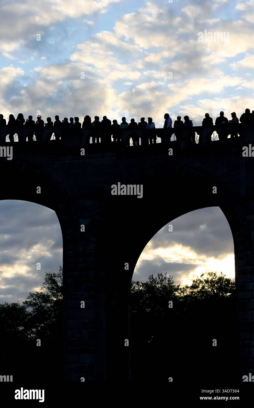 Gruppo di persone diverse sagome in piedi e guardando verso la luce. Piacere dopo aver completato il pellegrinaggio a Lourdes. Foto Stock