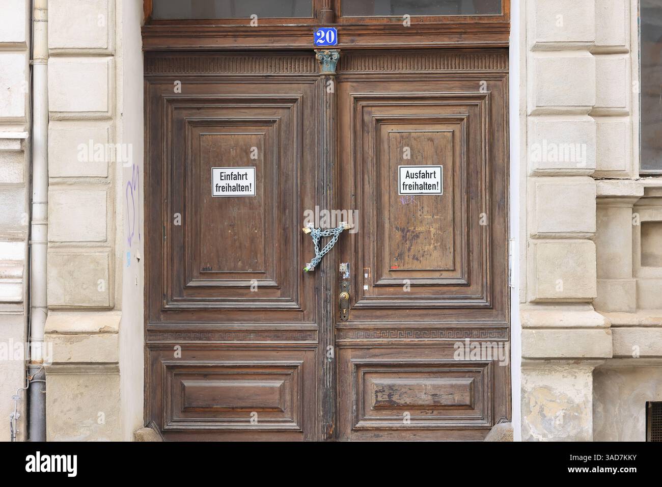 La porta d'ingresso di un edificio è protetta contro il furto con una serratura e una catena Foto Stock