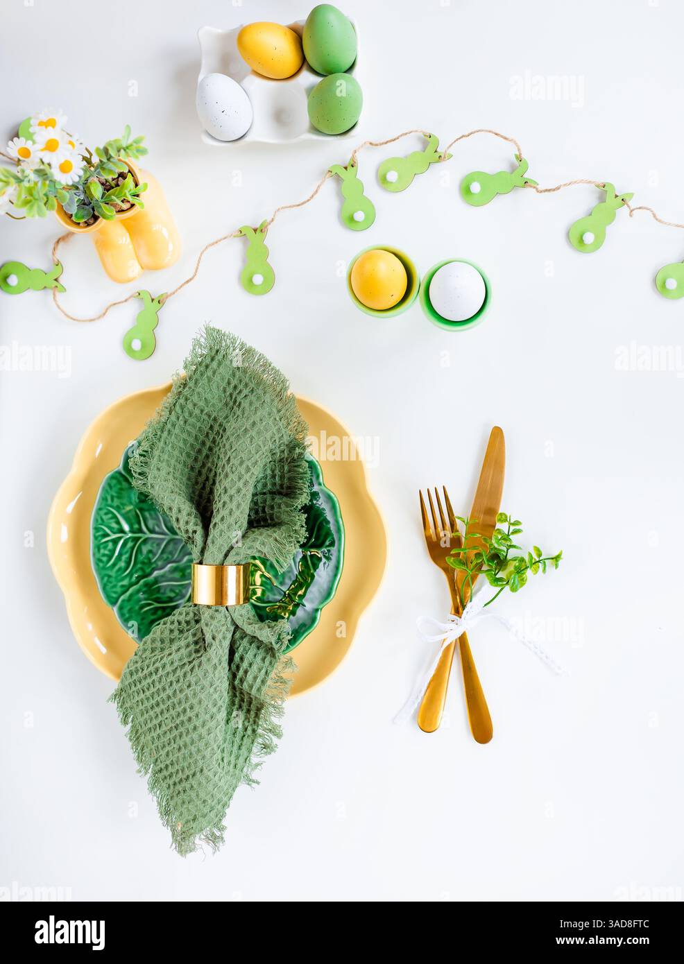 Buona Pasqua. Concetto di festa di Pasqua. Tovagliolo verticale con vista dall'alto piatto verde e giallo vuoto, uova di Pasqua, su sfondo bianco isolato. Copia spazio Foto Stock
