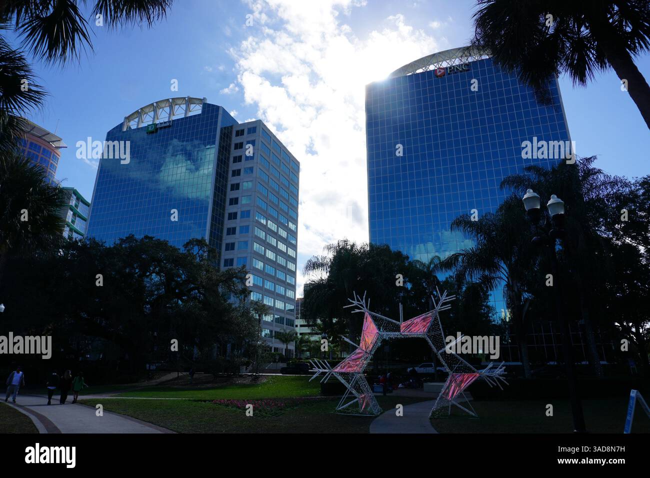 I grattacieli della Bank Tower circondano il Lake Eola Park, il cuore verde del centro di Orlando, Florida, Stati Uniti, pieno di palme e arte. Foto Stock