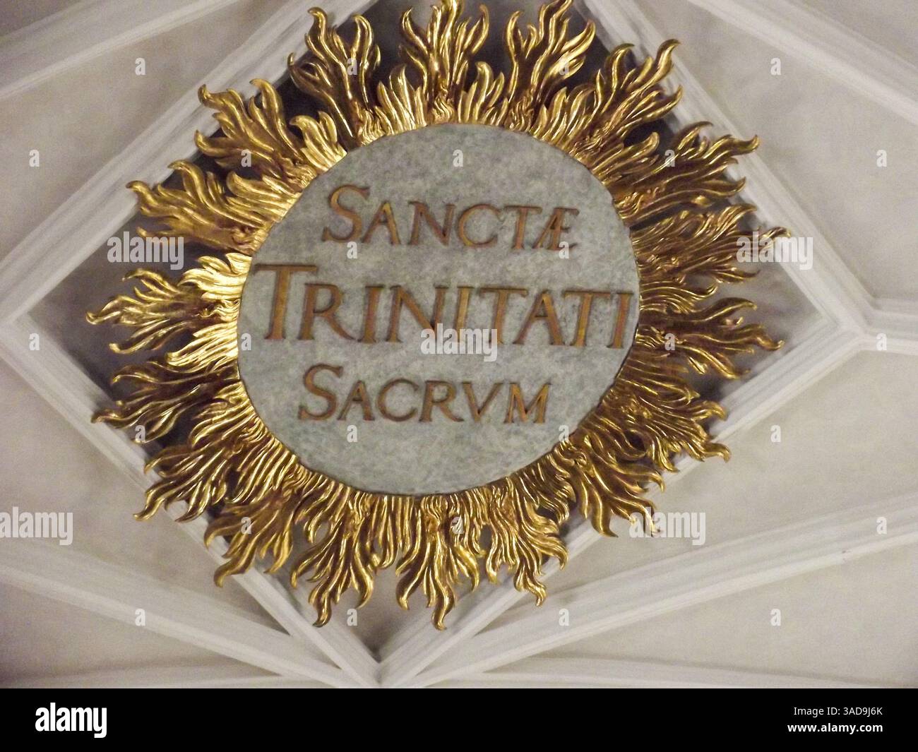 Un emblema decorativo del soffitto con un design Sunburst con al centro le parole latine "Sanctæ Trinitati Sacrum", che simboleggiano la Santissima Trinità. Foto Stock