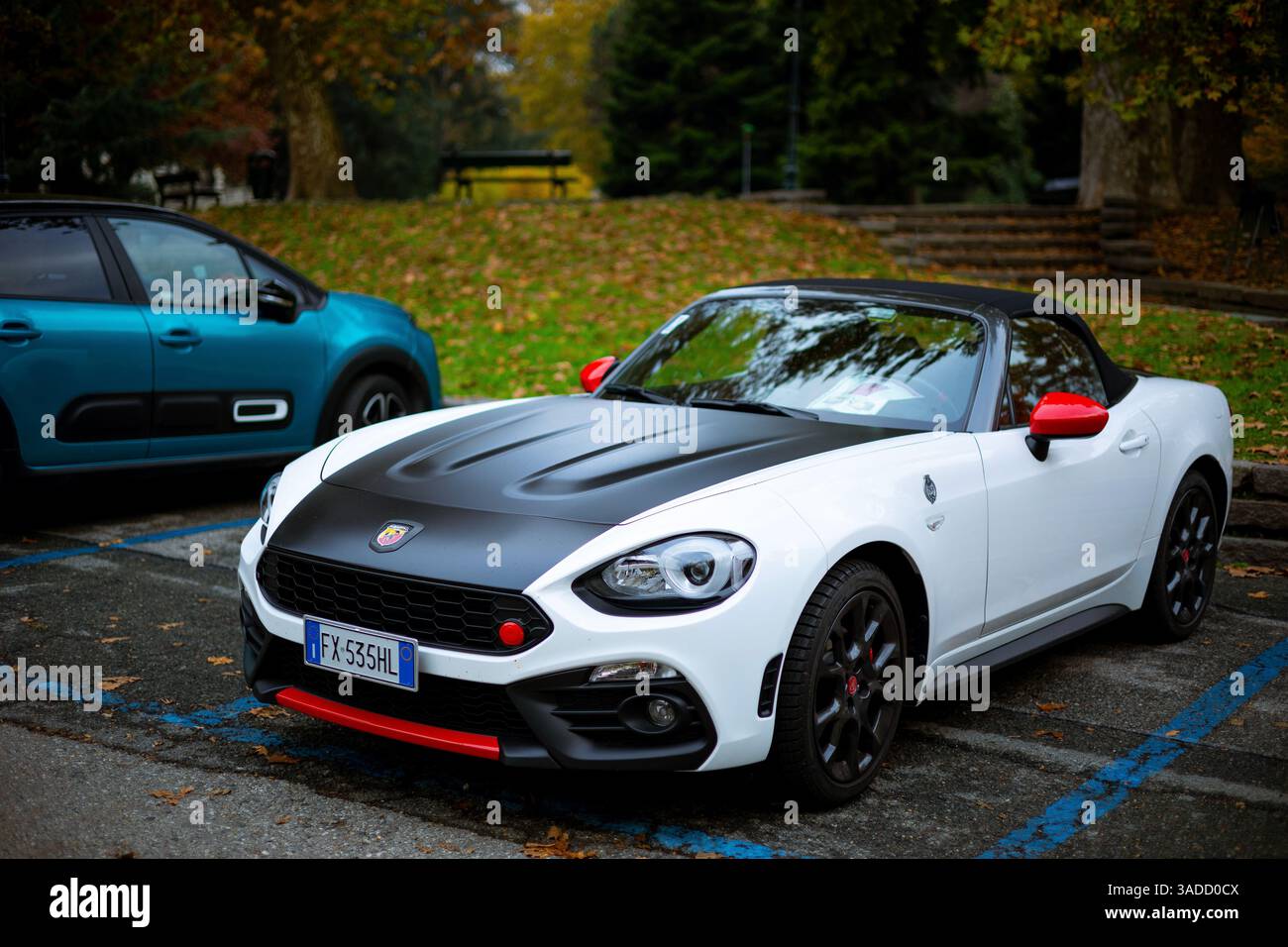 Torino, Italia - 08 novembre 2021: Una capote Abarth 124 Spider bianca con cappuccio nero e accenti rossi parcheggiata in un posto auto Foto Stock