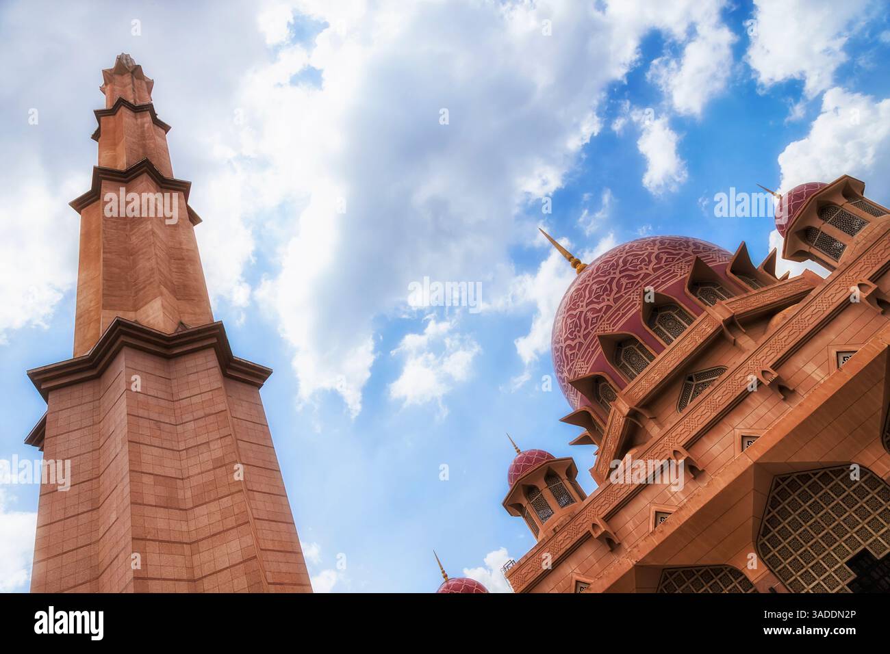 Vista dal basso verso l'alto delle cupole della Moschea Rossa e della torre del minareto dal cortile interno della capitale Putrajaya, Malesia. Foto Stock