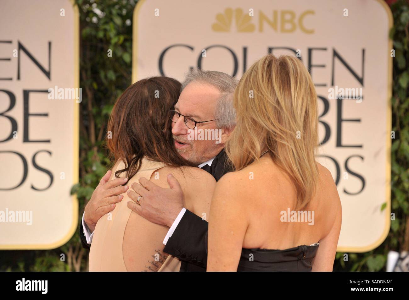 15 gennaio 2012 - Los Angeles, California, Stati Uniti - KRISTEN WIIG (L), STEVEN SPIELBERG e KATE CAPSHAW che indossano Yves S. Laurent, arrivano sul tappeto rosso per il 69° Golden Globe Awards. Wiig indossa un abito Bill Blass, gioielli Freid Leighton e scarpe Nicholas Kirkwood. Capshaw indossa Yves San Laurent. Spielberg è in Tom Ford. (Immagine di credito: © Leonard Ortiz/ZUMAPRESS.com) Foto Stock