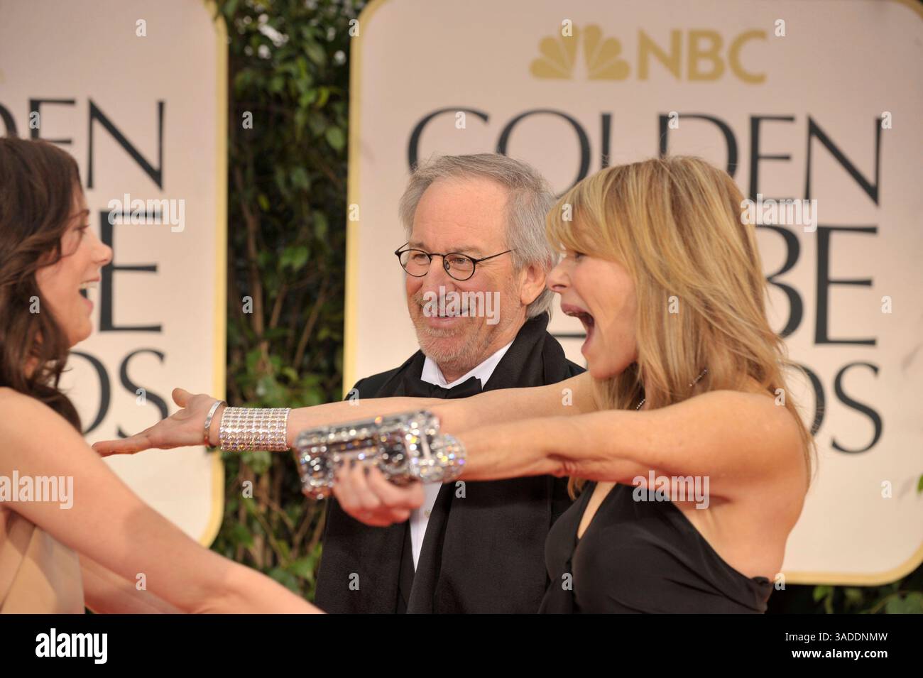 15 gennaio 2012 - Los Angeles, California, Stati Uniti - KRISTEN WIIG (L), STEVEN SPIELBERG e KATE CAPSHAW che indossano Yves S. Laurent, arrivano sul tappeto rosso per il 69° Golden Globe Awards. Wiig indossa un abito Bill Blass, gioielli Freid Leighton e scarpe Nicholas Kirkwood. Capshaw indossa Yves San Laurent. Spielberg è in Tom Ford. (Immagine di credito: © Leonard Ortiz/ZUMAPRESS.com) Foto Stock