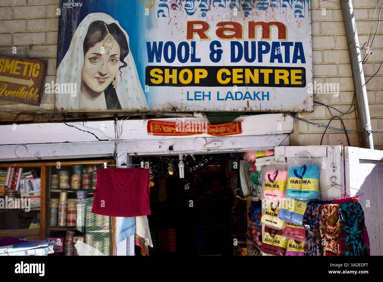 Vista sulla strada del RAM Wool & Dupata Shop Centre a Leh, Ladakh, che vende filati, abbigliamento e tessuti sotto un cartello dipinto a mano. Foto Stock