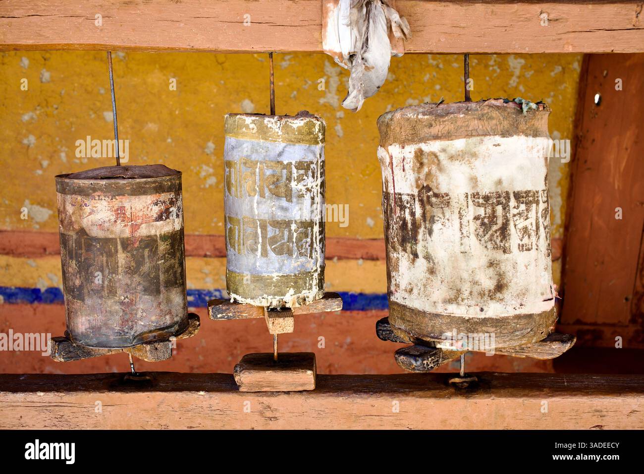 Ruote di preghiera tibetane sbiadite che portano tracce di Om mani Padme Hum mantra all'interno del monastero di Likir, Ladakh, India. Foto Stock