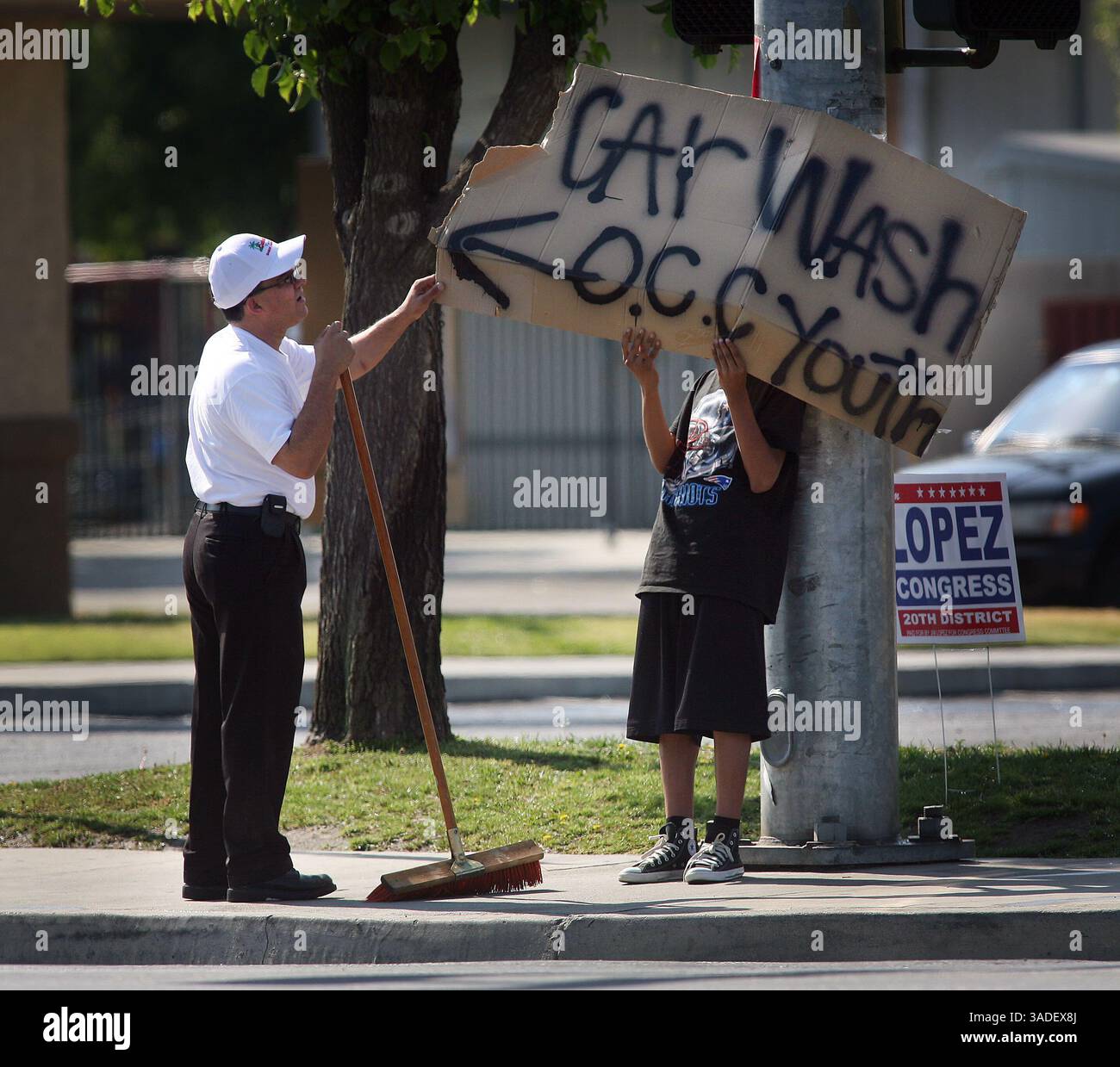 Casey Christie / The Californian. Il proprietario del nuovo ristorante Cuban Flavor su California Avenue e Chester Avenue, Sergio Aguilar, ha lasciato, controlla il cartello del lavaggio auto tenuto da Fernando Romero, (immagine di credito: The Bakersfield Californian/ZUMAPRESS.com) Foto Stock