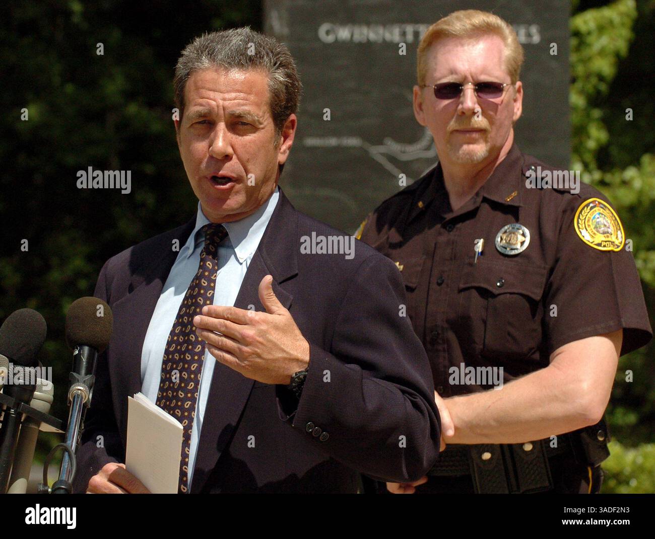 25 maggio 2005; Lawrenceville, GA, Stati Uniti; il procuratore distrettuale della contea di Gwinnett DANNY PORTER, a sinistra, si rivolge ai media, fuori dal Gwinnett Justice and Administration Center di Lawrenceville, GA, per le accuse contro la sposa fuggitiva Jennifer Wilbanks. Porter ha annunciato che Wilbanks è stata incriminata mercoledì con l'accusa di aver mentito alla polizia sostenendo di essere stata rapita. Se condannata, potrebbe affrontare fino a sei anni di prigione e ricevere l'ordine di rimborsare la polizia per gli oltre 50.000 dollari spesi per la sua ricerca di tre giorni. In piedi Porter e' il Duluth, capo della polizia, RANDY BELCHER. ( Foto Stock