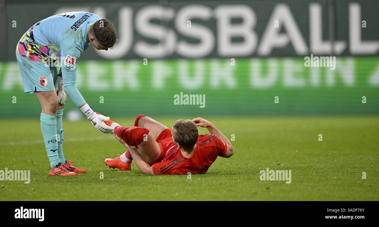 Fair play, il portiere Finn Dahmen FC Augsburg FCA (01) aiuta Harry Kane FC Bayern Monaco FCB (09) a mettersi in piedi dopo un infortunio, nel perimetro dello sfondo Foto Stock