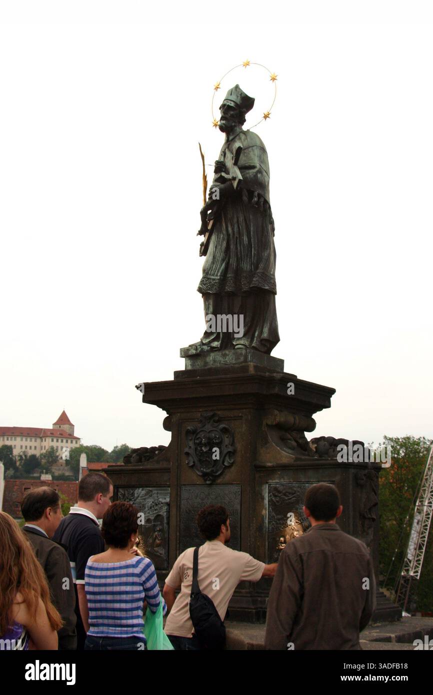 10 giu 2004; Praga, Repubblica Ceca; toccando i pannelli in fondo al saté di San Giovanni di Nepomuk sul Ponte Carlo si suppone che porti fortuna. Il destino non troppo fortunato di San Giovanni doveva essere torturato a morte e il suo corpo gettato da questo ponte nel 1393 per essersi rifiutato di divulgare la confessione della regina. (Immagine di credito: Kayte Deioma/ZUMAPRESS.com) Foto Stock