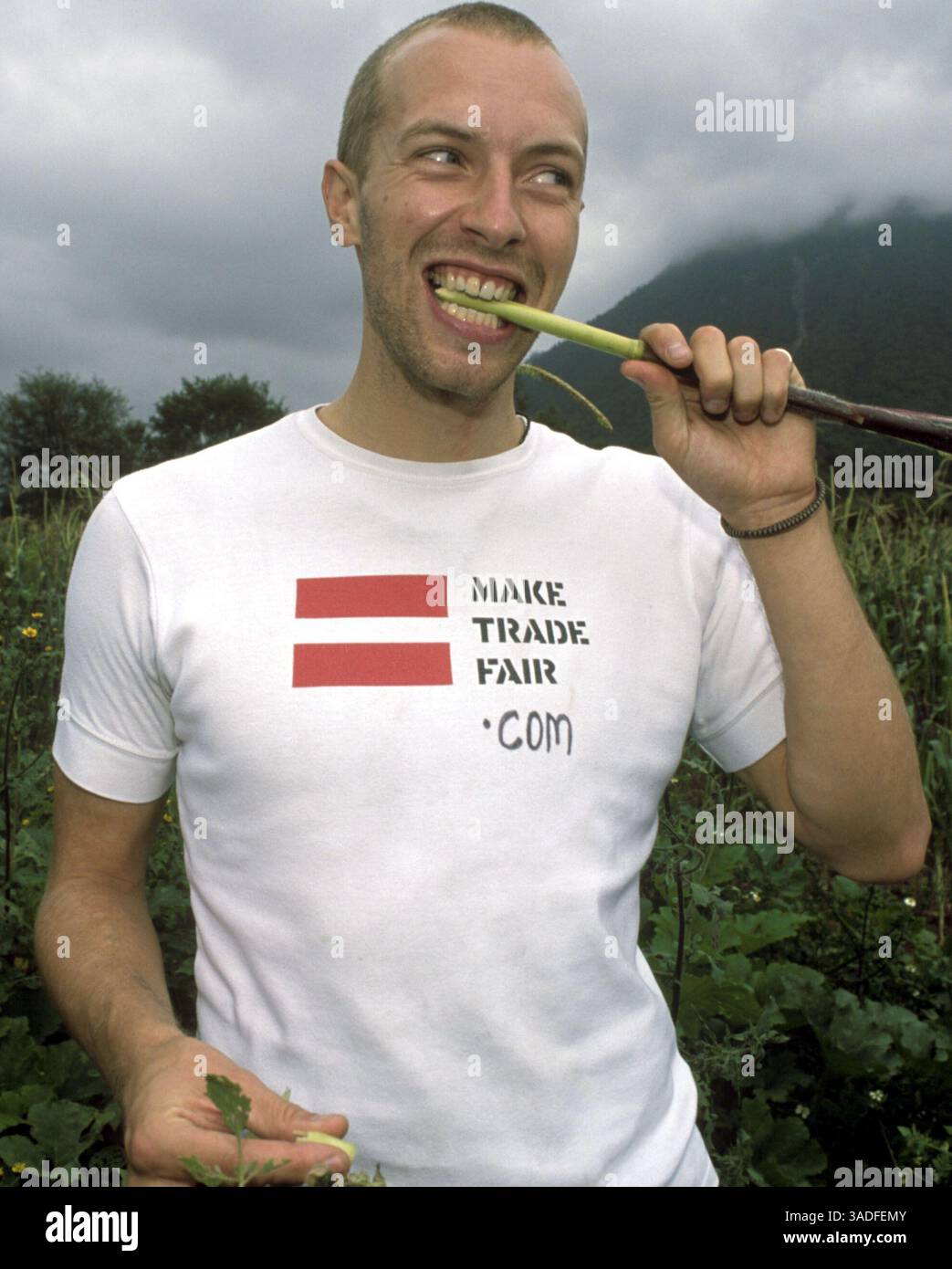 Il cantante dei Coldplay CHRIS MARTIN assaggia un pezzo di gambo di mais dolce nei campi di mais del villaggio di Santa Isabel Tepetzala, Puebla, Messico. "Coldplay" ha visitato i coltivatori di mais messicani per sostenere la campagna "Make Trade Fair" della ONG britannica Oxfam. La campagna chiede ai governi di ridurre le sovvenzioni agli agricoltori dei paesi ricchi ed eliminare il dumping dei prodotti agricoli. (Immagine di credito: Keith Dannemiller/ZUMAPRESS.com) Foto Stock