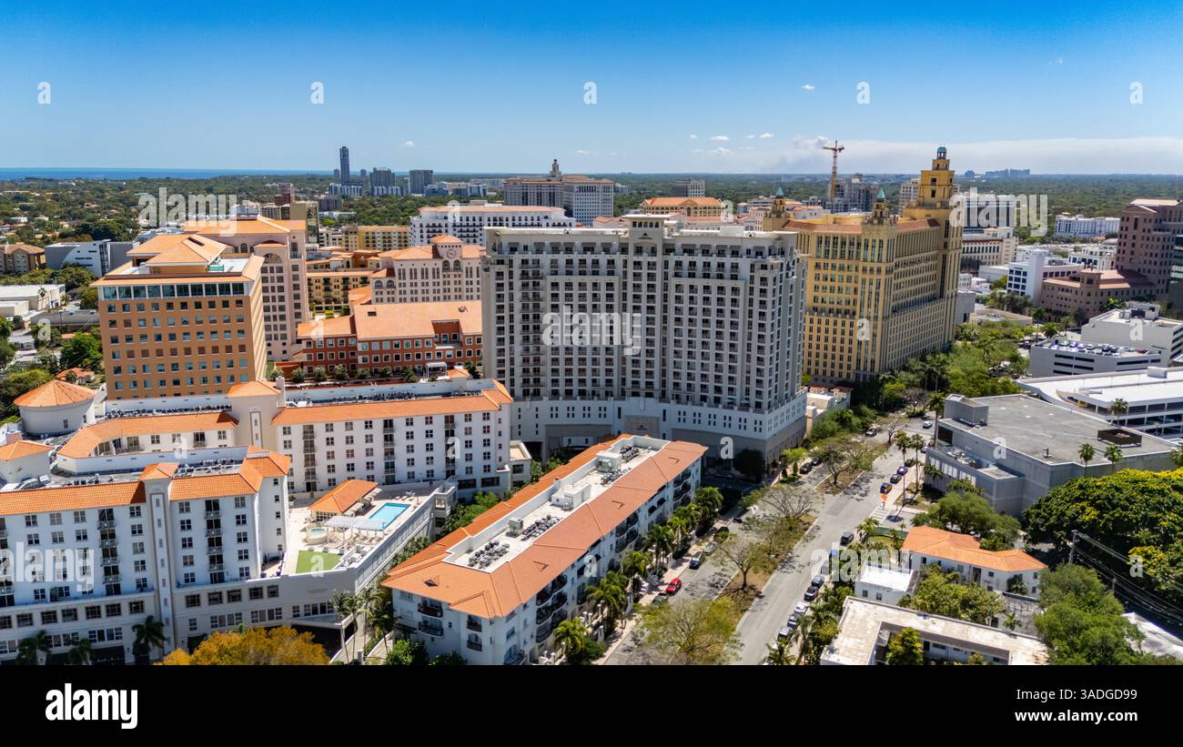 Moderni edifici in stile mediterraneo fiancheggiano il centro di Coral Gables, Florida, sotto un cielo azzurro vivace in una giornata di sole. Foto Stock