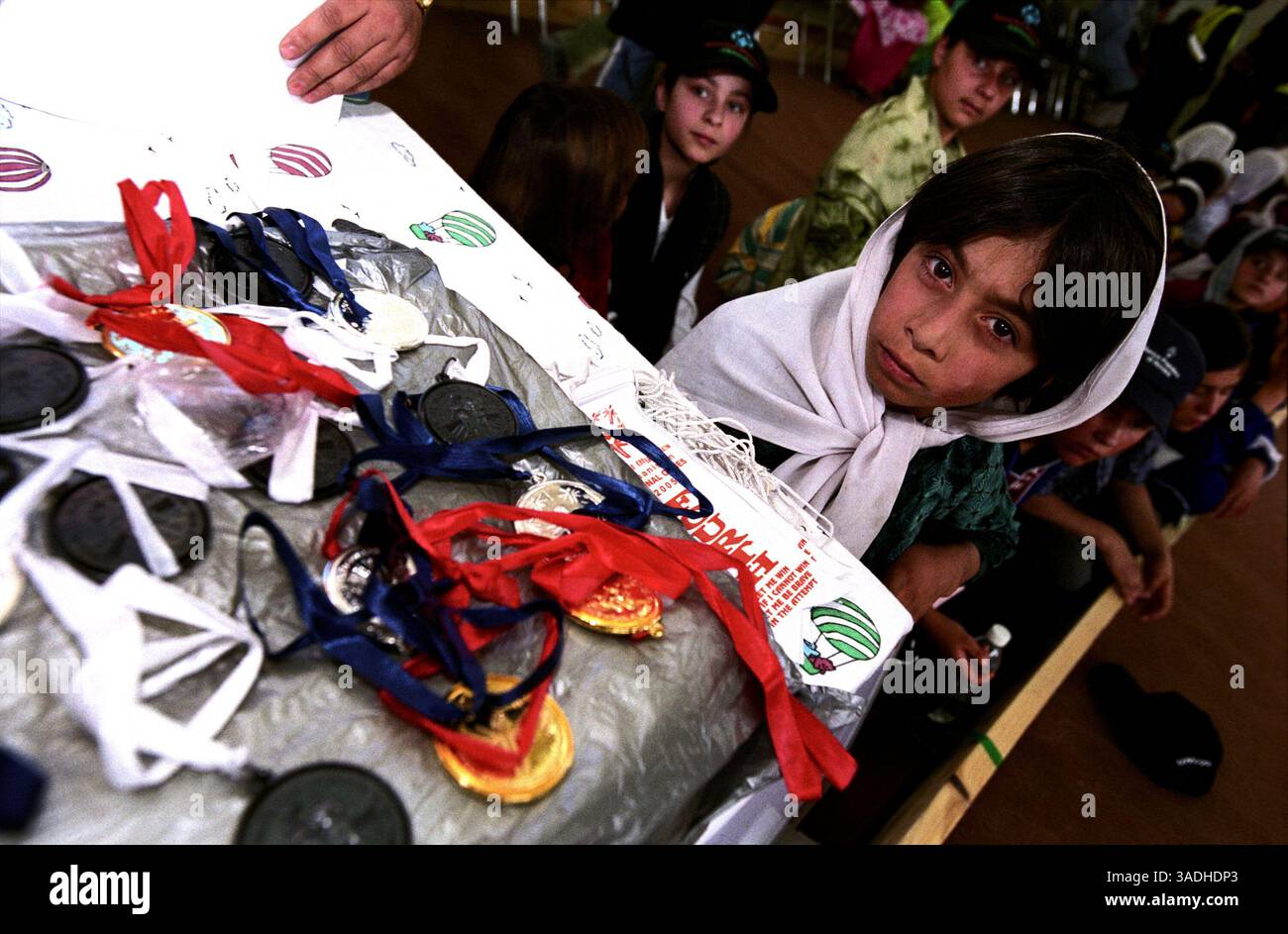24 agosto 2005; Kabul, AFGHANISTAN; Una giovane atleta, con indosso una sciarpa bianca, si siede vicino al tavolo della giuria dove sono conservate le medaglie olimpiche. Più di 300 atleti, tra cui 80 donne, hanno sperimentato per la prima volta nella loro vita un assaggio di felicità e successo. Gareggiavano nell'atletica leggera, nelle bocce e nel calcio. A causa delle restrizioni culturali, maschi e femmine gareggiavano in luoghi separati. (Immagine di credito: Kash Gabriele Torsello/ZUMAPRESS.com) Foto Stock