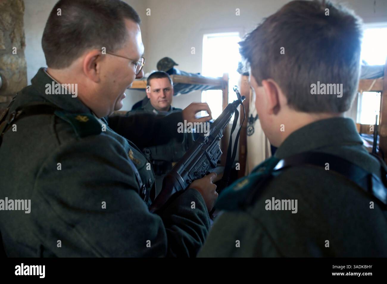 24 gennaio 2005; Fort Washita, Oklahoma, Stati Uniti; un reenattore mostra la procedura per gestire correttamente una mitragliatrice d'epoca a un partecipante più giovane in un raduno di reenattori della seconda guerra mondiale a Fort Washita, Oklahoma. Le truppe tedesche coinvolte nella ricostruzione di Fort Washita includevano la 1.SS Panzer Division Leibstandarte, istituita nel 1978. Un'unità molto popolare, secondo le 287.000 hit ricevute dal suo sito web da quando è stato istituito nel 1998. La Leibstandarte fu la prima divisione Panzer SS istituita dai nazisti, e il suo nome completo storicamente corretto è in realtà "Leibstandarte SS Adolf Hitler". (CR Foto Stock