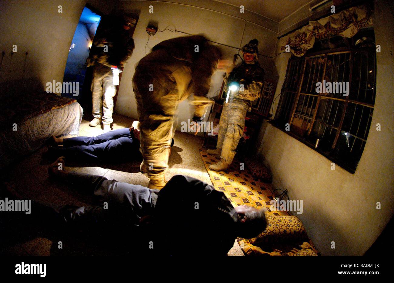 16 settembre 2005; Mosul, IRAQ; Un soldato protegge due detenuti mentre un ufficiale dell'intelligence militare parla con loro durante un raid il 16 settembre 2005 a Mosul. La fanteria fa parte del 172nd Stryker Brigade Combat Team di Fort Wainwright, Alaksa. (Immagine di credito: Bill Putnam/ZUMAPRESS.com) Foto Stock