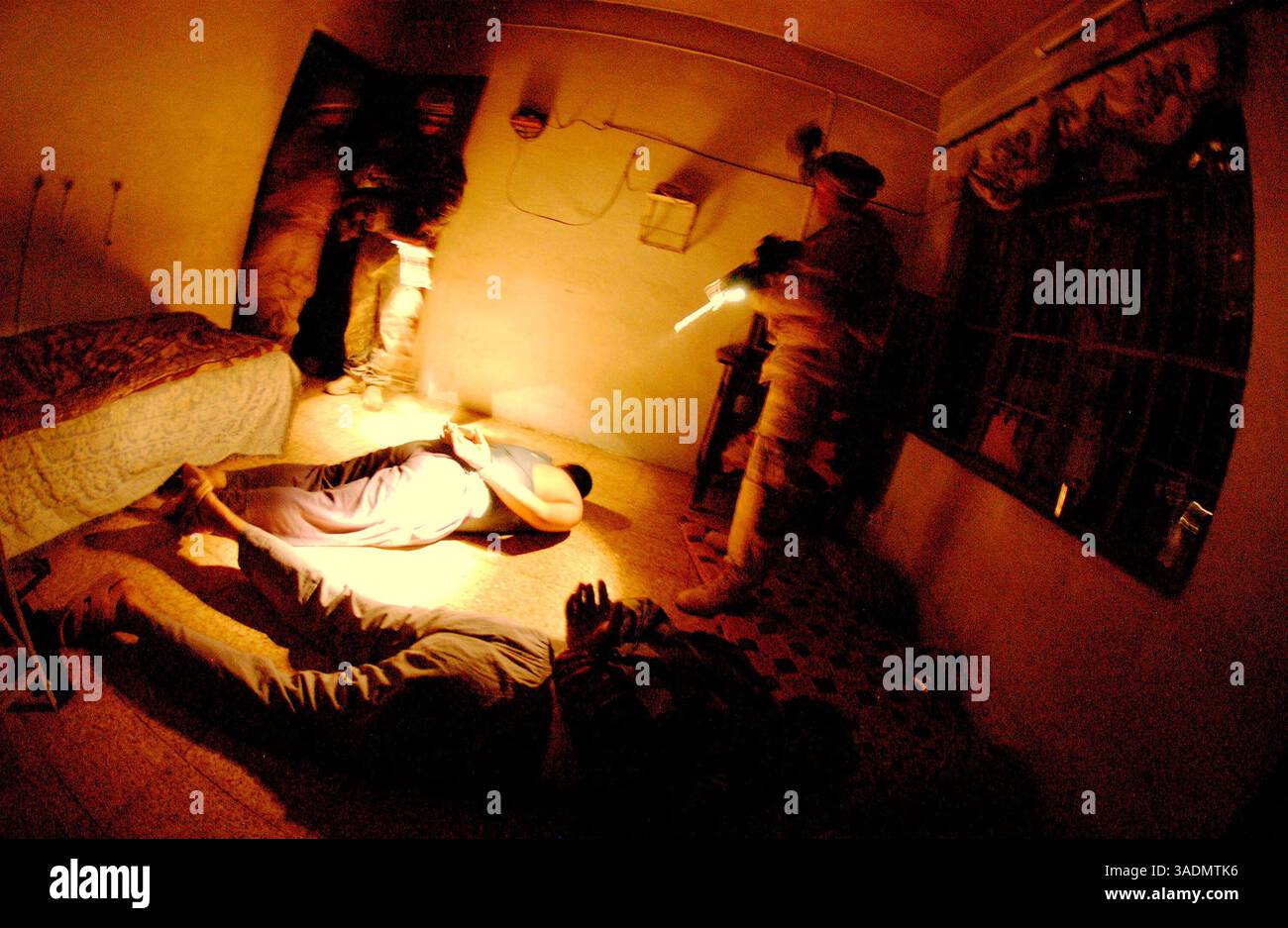 16 settembre 2005; Mosul, IRAQ; Un soldato protegge due detenuti mentre un ufficiale dell'intelligence militare parla con loro durante un raid il 16 settembre 2005 a Mosul. La fanteria fa parte del 172nd Stryker Brigade Combat Team di Fort Wainwright, Alaska. (Immagine di credito: Bill Putnam/ZUMAPRESS.com) Foto Stock