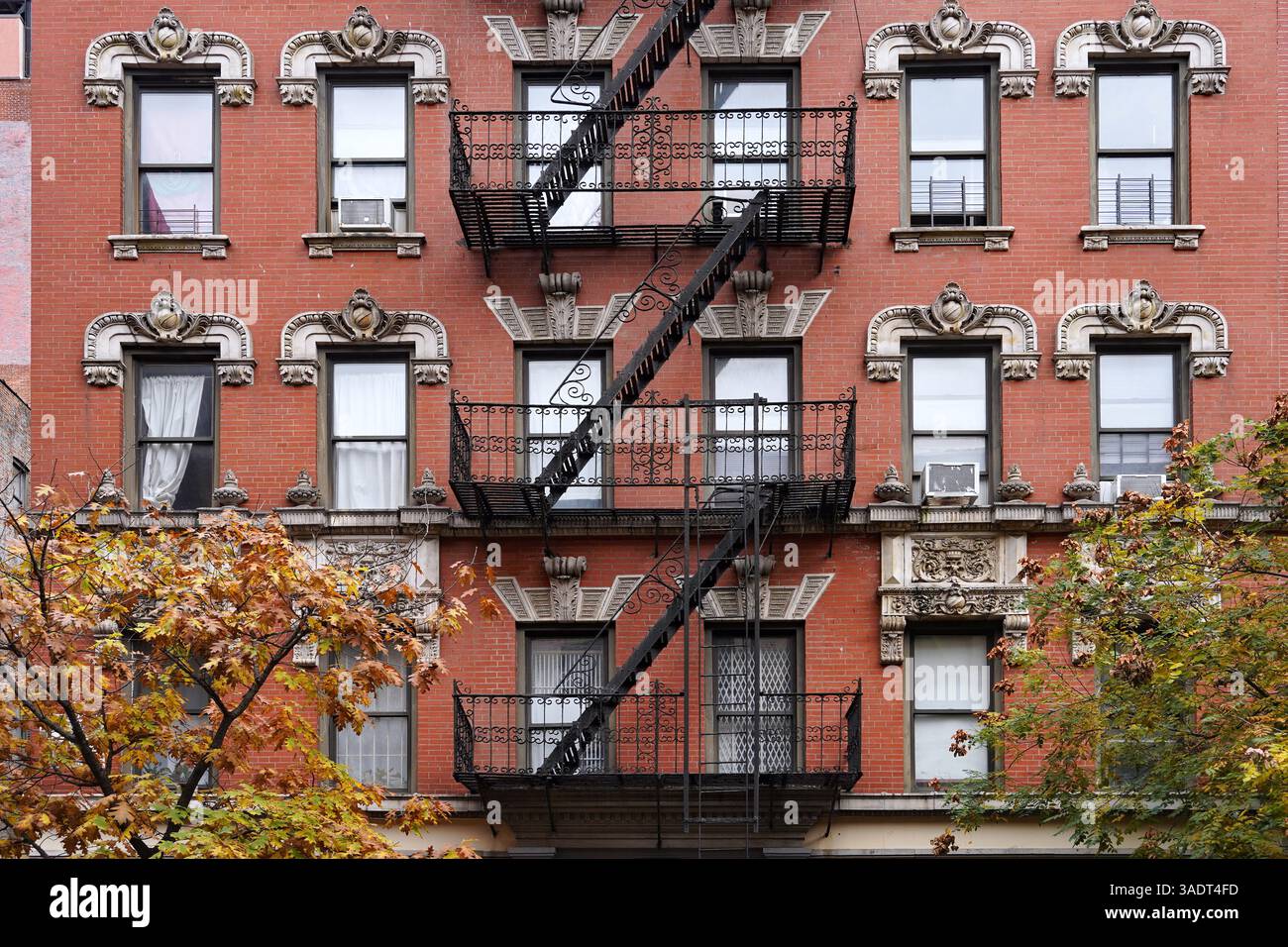 Vecchio edificio di appartamenti di New York con modanature ornate davanti a un'uscita antincendio Foto Stock