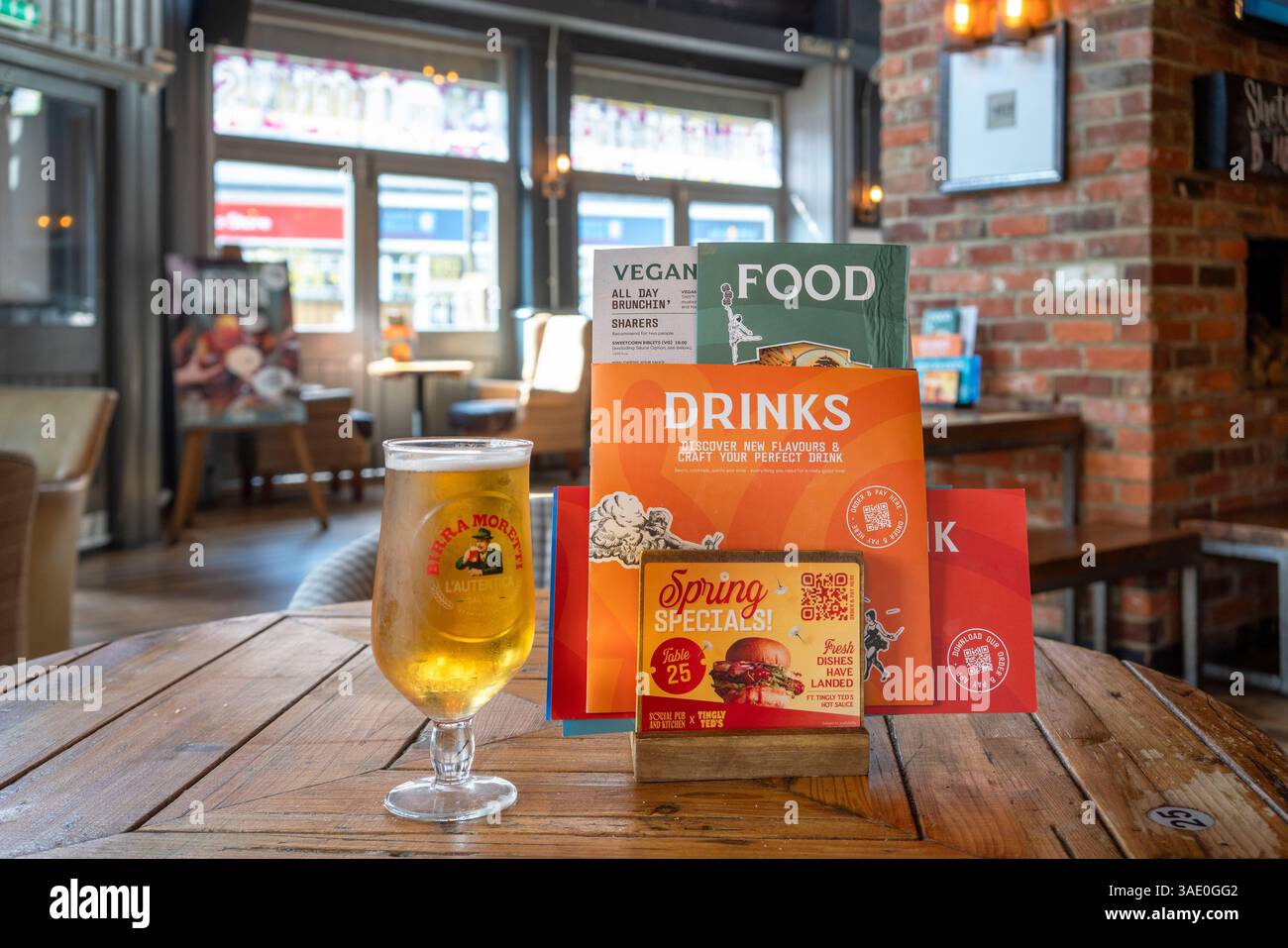 Menu di bevande e cibo da pub con un bicchiere di birra su un tavolo di legno Foto Stock
